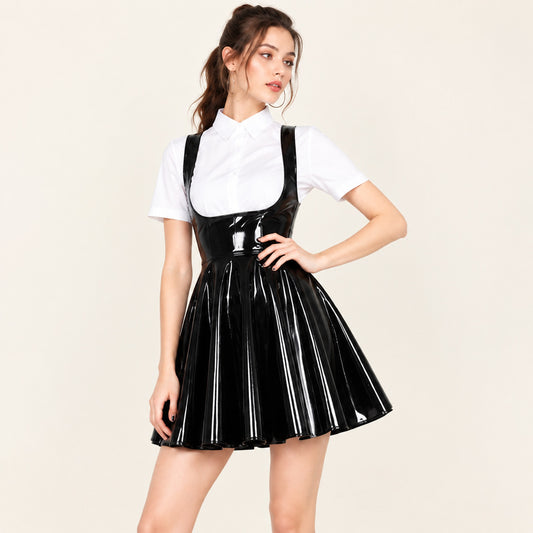 Model wearing black shiny faux leather pleated pinafore mini dress